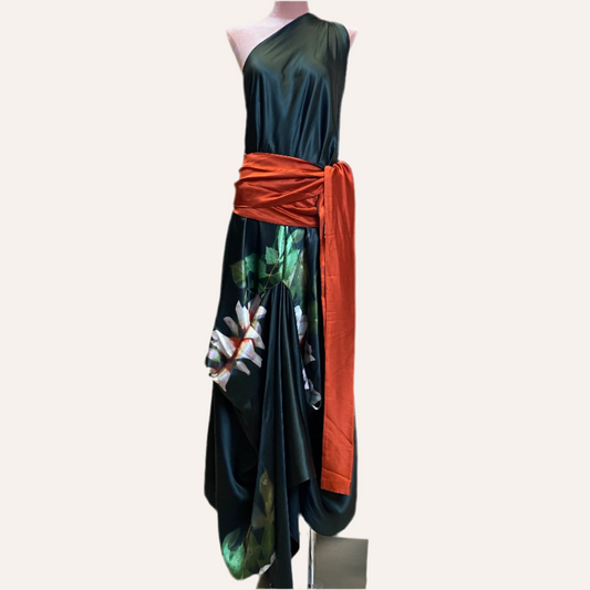 Mannequin wearing a black dress with floral patterns and an orange sash on a white background