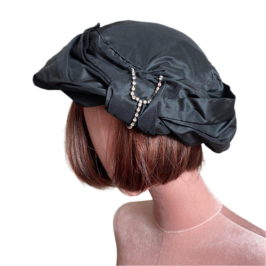 Elegant silk taffeta turban with a luxurious sheen, designed for a sophisticated and stylish look. Perfect for special occasions or adding a chic touch to everyday outfits.