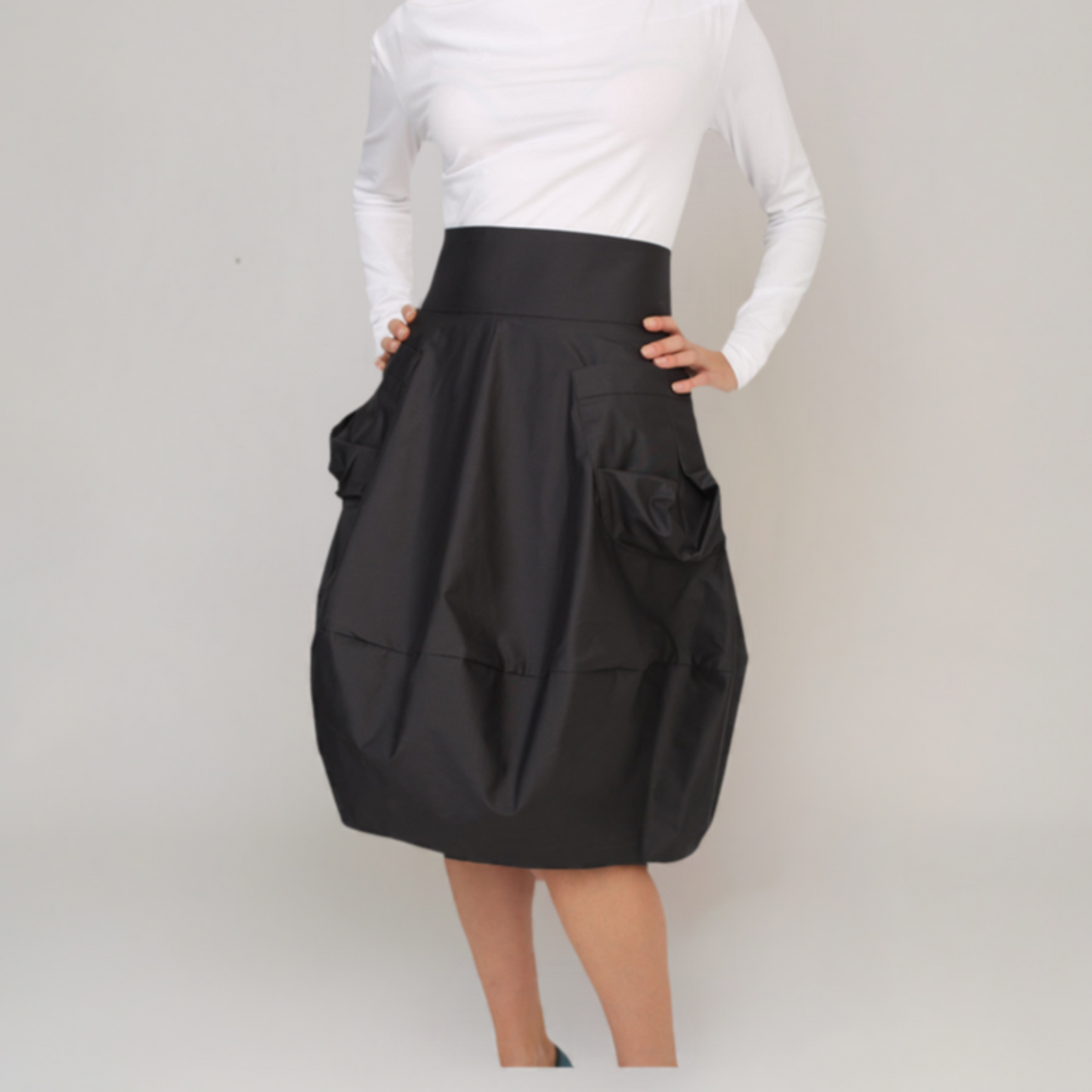 Bubble style skirt in oyster colour cotton. Below the knees. Skirt with two oversized pockets 