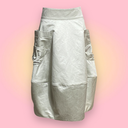 Bubble style skirt in oyster colour cotton. Below the knees. Skirt with two oversized pockets 